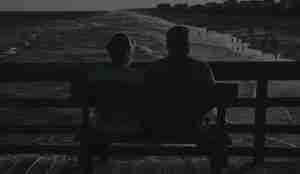 Two aged people sitting on a bench