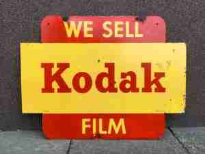 An image of an old and rusty sign reading 'we sell Kodak Film'