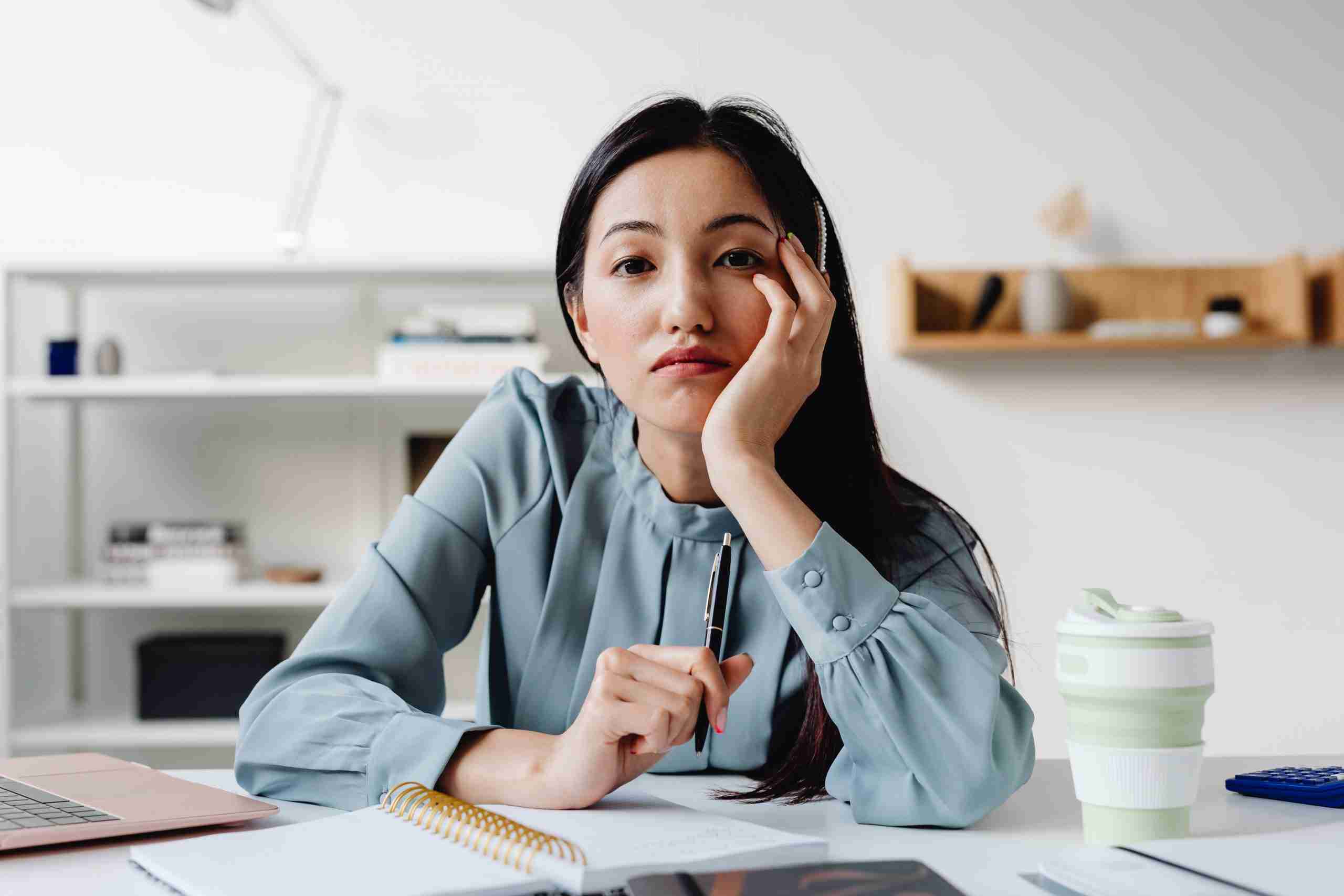 An image of a young woman at an office, looking bored, conveying the negative impact of a bad employee value proposition.