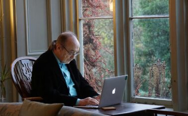 man in black suit jacket using macbook