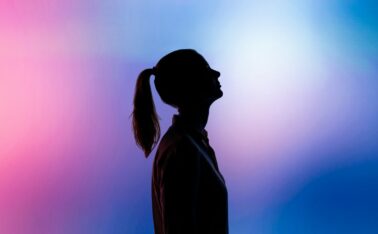 silhouette of woman wearing black hat and black coat